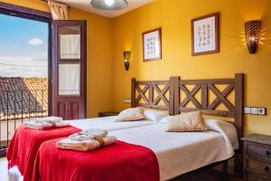 two beds in a room with yellow walls at Las Puentes 1 in Candelario