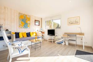 a living room with a couch and a desk at La Cabane - 10 min du port in Combrit