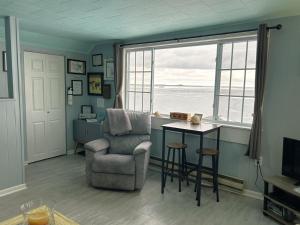 a living room with a chair and a table and a window at Bayview #1 in Saint Ignace