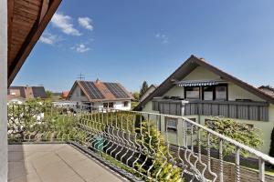 a house with a white fence and a balcony at Haus Ella in Königsfeld im Schwarzwald