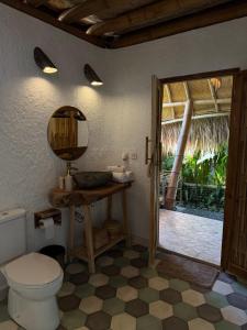 a bathroom with a toilet and a door to a patio at Batu Kayu Medewi in Medewi