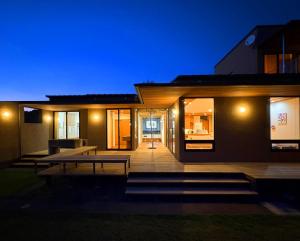 une maison avec une terrasse en bois la nuit dans l'établissement 隠れ家アートヴィラ Villa Revolla, à Makinohara