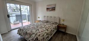 サンクチュアリ・ポイントにあるGreville Getaway - Absolute Waterfrontのベッドと大きな窓のある寝室