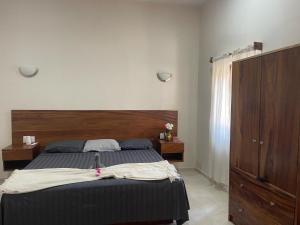 a bedroom with a large bed with a wooden headboard at Casa Maria Bonita in Troncones