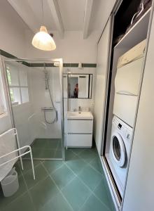 a bathroom with a sink and a washing machine at Le Pré Des Fées in La Ferté-Imbault