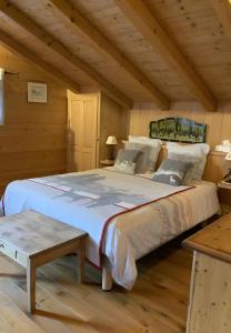 a bedroom with a large bed in a log cabin at Chalet Des Fleurs in Combloux