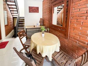 - une table et des chaises dans une pièce dotée d'un mur en briques dans l'établissement Huiz de Rico Guesthouse Syariah near Ambarrukmo Area, à Demangan