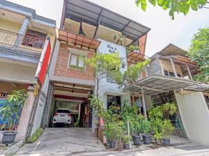 un bâtiment avec des plantes devant lui dans l'établissement Huiz de Rico Guesthouse Syariah near Ambarrukmo Area, à Demangan