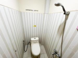 une petite salle de bain avec toilettes et douche dans l'établissement Huiz de Rico Guesthouse Syariah near Ambarrukmo Area, à Demangan