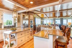 a large kitchen with white cabinets and wooden ceilings at Tenth Street Retreat in Tybee Island