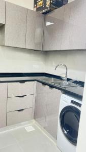 a kitchen with a washing machine and a sink at مسقط العامرات in ‘Udhaybah