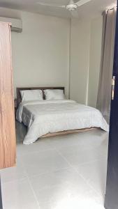 a bedroom with a large bed with white sheets at مسقط العامرات in ‘Udhaybah