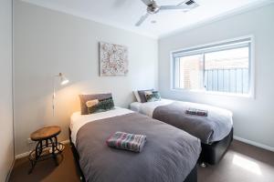 two beds in a room with a window at The Lake House - Spacious Group Haven by the Bay in Victor Harbor