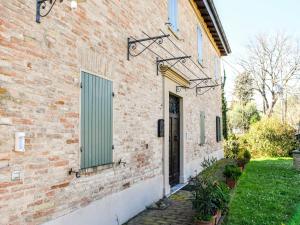 Fiorenzuola di FocaraSpacious apartment in a stone farmhouse的一栋带有门和绿色百叶窗的砖砌建筑