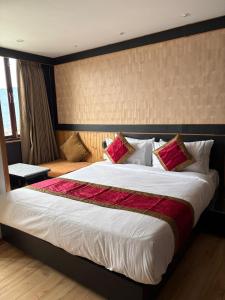 Un dormitorio con una cama grande con una manta roja. en Hotel Mist Tree Mountain, en Gangtok