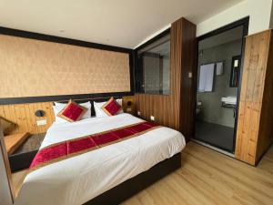 Un dormitorio con una gran cama blanca con almohadas rojas. en Hotel Mist Tree Mountain, en Gangtok 2 fotos más