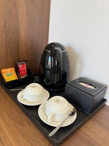 un plateau avec une théière, des assiettes et une boîte dans l'établissement Paradise Mountain View Resort, à Vang Vieng