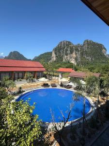 une grande piscine bleue avec une montagne en arrière-plan dans l'établissement Paradise Mountain View Resort, à Vang Vieng