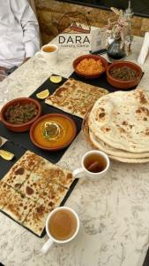 a table with plates of food and cups of coffee at DARA RUM lUXURY CAMP in Wadi Rum