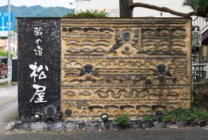 a stone wall with writing on it on a street at Kuranoyado Matsuya in Fujikawaguchiko