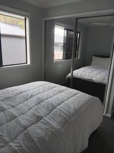 a bedroom with a white bed and a window at Melaleuca Homestay in Bahrs Scrub +4 photos