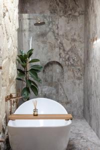 a white bath tub with a plant on top of it at Villa Nida Premium by Tofino Villas in Uluwatu +30 photos