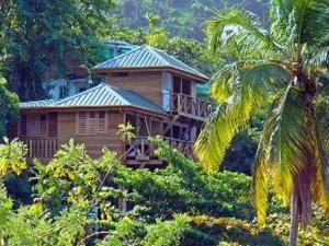 a wooden house in the middle of a forest at SeaScape on Heavenly Bay in Castara