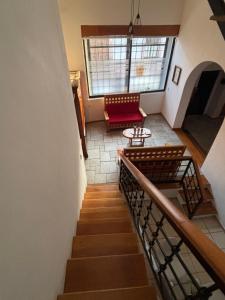 a staircase with a chair and a table in a building at Casa Colibrí Querétaro in Querétaro