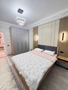 a bedroom with a large bed and a chandelier at Элеганс в Континенталь in Bishkek