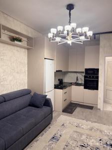 a living room with a couch and a kitchen at Элеганс в Континенталь in Bishkek