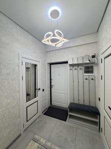 a room with a hallway with lockers and a chandelier at Элеганс в Континенталь in Bishkek