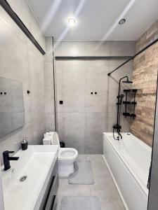 a bathroom with a tub and a toilet and a sink at Элеганс в Континенталь in Bishkek
