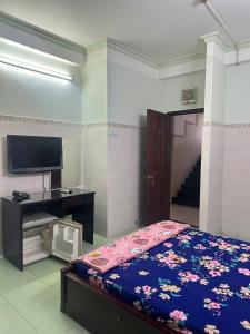 胡志明市Khách Sạn GIANG PHƯỚC HÙNG的一间卧室，里面有一张床和一台平板电视