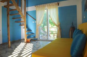 1 dormitorio con cama, ventana y escalera en B&B El Mirador al Mar, en Sosúa