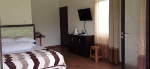 a hotel room with a bed and a television at Guesthouse Sadamantra in Maniskaler