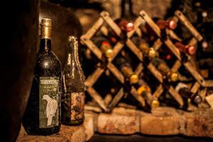 two bottles of wine are sitting next to a bunch of wine bottles at Boutique Hotel Golf Garni in Mikulov
