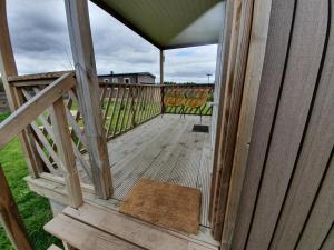 un porche de madera con una alfombra en una terraza en Holiday home in Schoonloo with balcony terrace, en Schoonloo