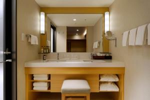 a bathroom with a sink and a large mirror at Hotel Metropolitan Tokyo Ikebukuro in Tokyo