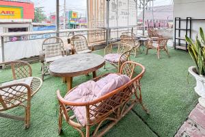 RedDoorz near Alun Alun Subang 2 في سوبانج: مجموعة من الكراسي والطاولات على الشرفة
