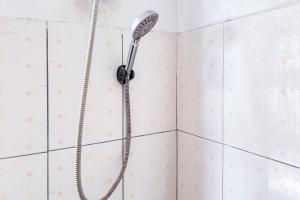 RedDoorz near Alun Alun Subang 2 في سوبانج: دش مع رأس دش على جدار من البلاط