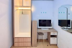 RedDoorz near Alun Alun Subang 2 في سوبانج: غرفة بها مكتب وبه جهاز كمبيوتر