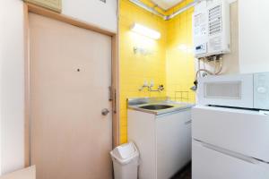 a small kitchen with a sink and a white refrigerator at 池袋駅徒歩5分 Mejiro Yasu Hotel in Tokyo +91 photos