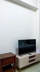 a flat screen tv sitting on top of a wooden entertainment center at Cozy Modern Studio Overlooking the Skyline in Molo