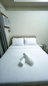 a roll of toilet paper sitting on a bed at Cozy Modern Studio Overlooking the Skyline in Molo