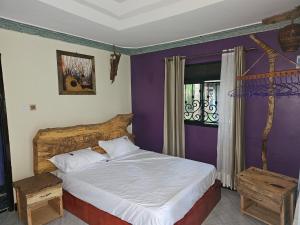 a bedroom with a large bed and a window at Nguru Farm Cottages in Kabale +37 photos