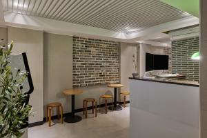 Unit M Hostel في سول: بار به مقاعد وجدار من الطوب