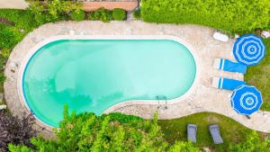 an overhead view of a swimming pool with blue umbrellas at Villa Alexandre III in Dijon +15 photos