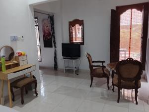 a living room with a table and chairs and a television at Kuta Grace house Bali in Kuta