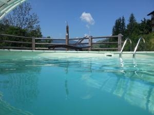 uma piscina com um escorrega de água ao fundo em Villa Ortensia em San Vigilio Di Marebbe
