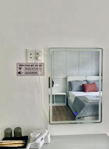 a mirror reflecting a bedroom with a bed in it at Hoàng Huy Hotel in Cat Ba
